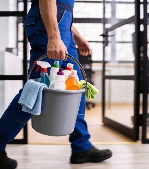 Professional,Cleaning,Worker,Wearing,Uniform,And,Walking,Indoors,While,Carrying