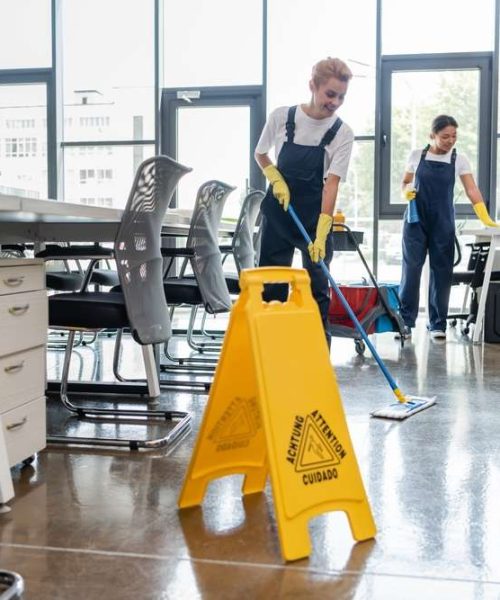 Woman,In,Overalls,Washing,Floor,With,Mop,Near,Attention,Board